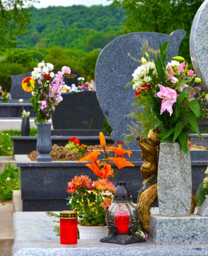 Sveče in šopki rož na grobovih